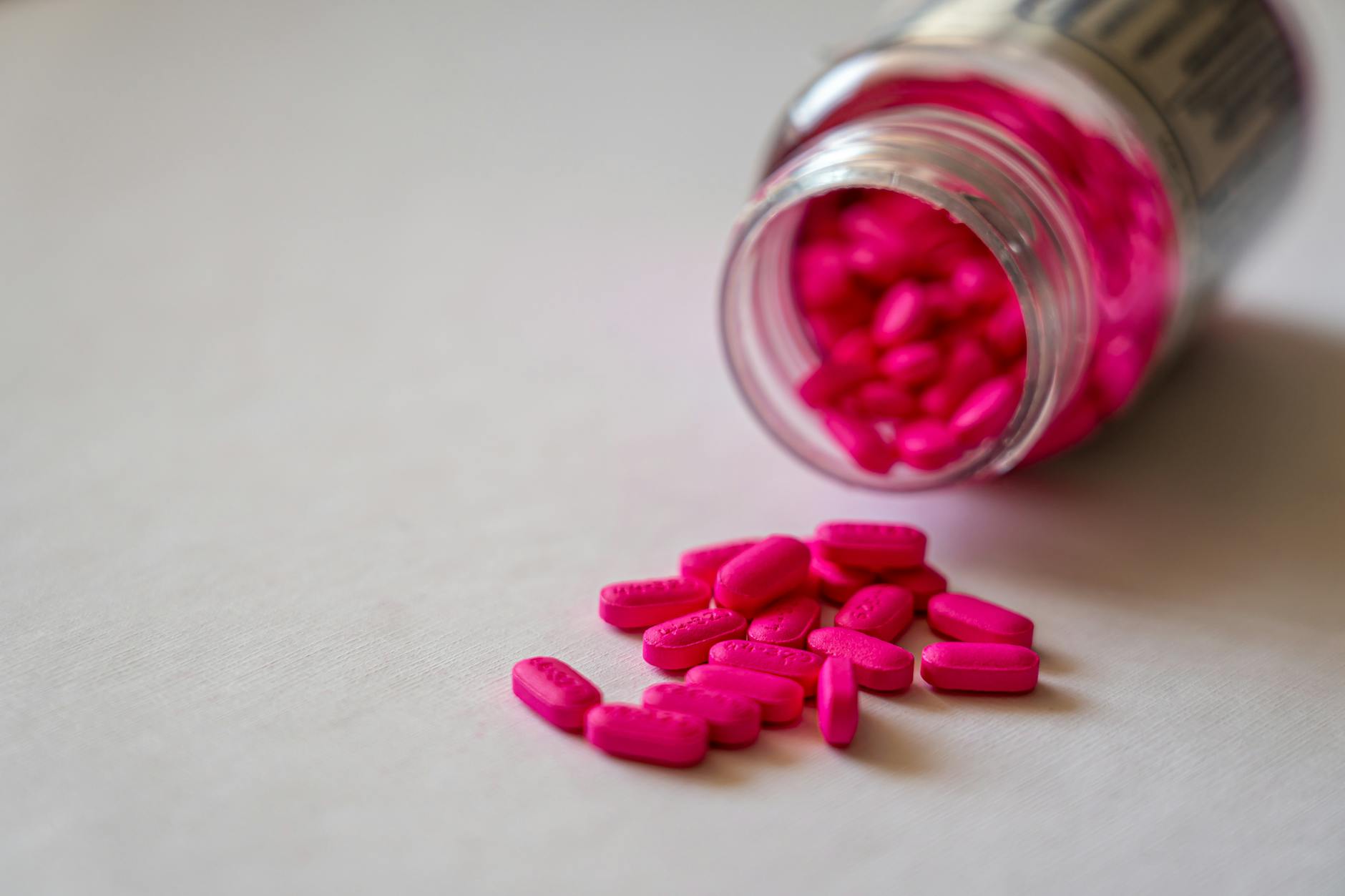 pink medication pills in clear glass jar