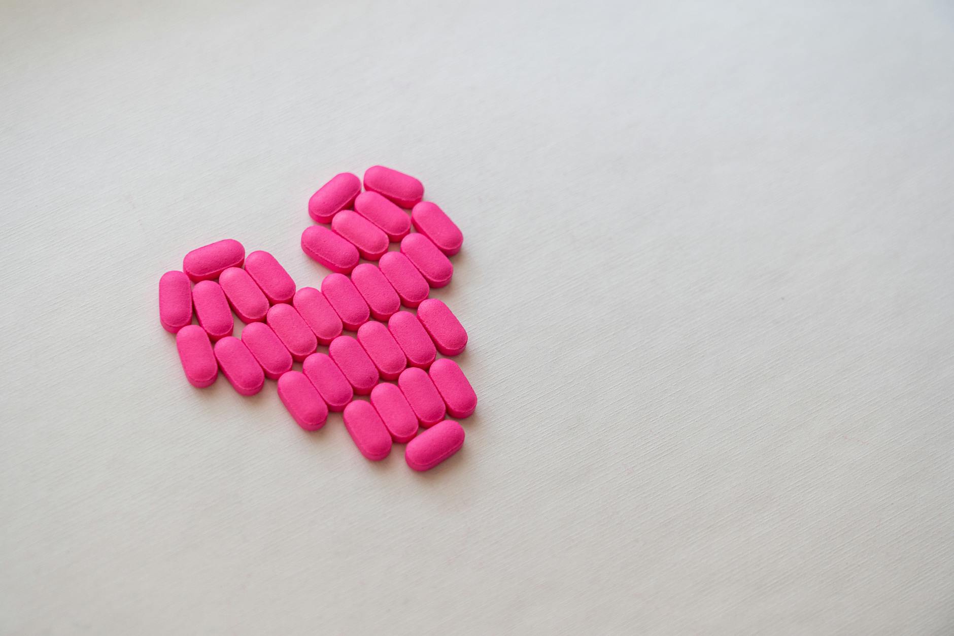 pink medication pill on white surface