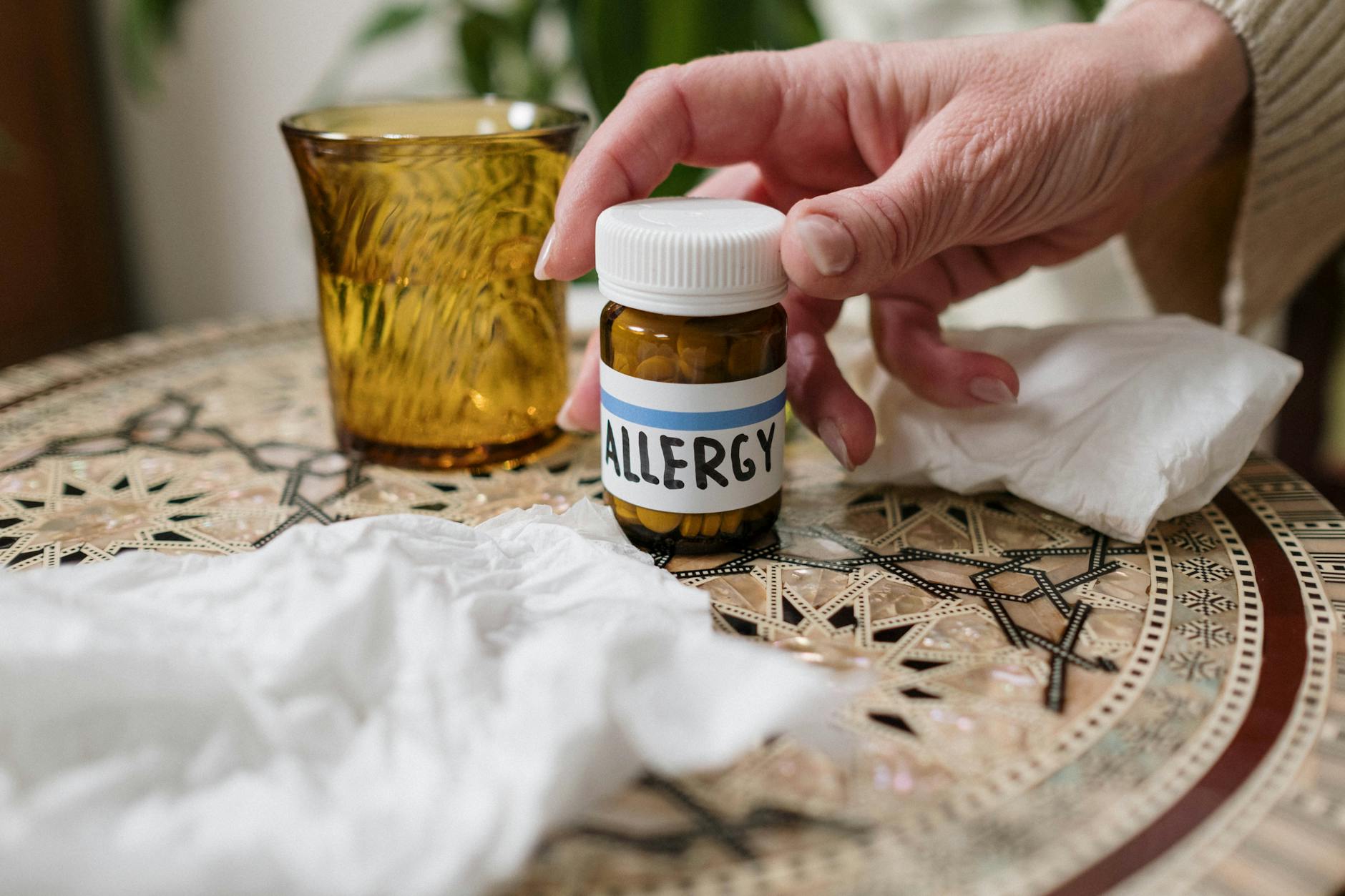 person holding allergy medicine bottle